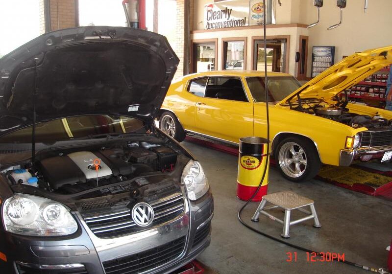 Two cars with an open hood exposing the engine